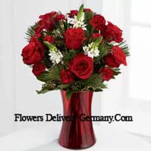 This romantic arrangement bristles with the passion and wonder of the Christmas season. Rich red roses and burgundy mini carnations accented with the snowy white blooms of Stars of Bethlehem, pine branches, and lush greens will easily sweep them off their feet. Arranged in a ruby red clear glass vase, this bouquet conveys your most heartfelt holiday wishes. (Please Note That We Reserve The Right To Substitute Any Product With A Suitable Product Of Equal Value In Case Of Non-Availability Of A Certain Product)
