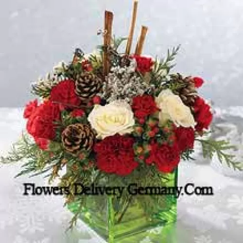Send this bouquet of holiday colours - white roses, red carnations and Christmas greens - to express your happiest holiday wishes. Arranged in a glass cube with cinnamon sticks and pinecones, it's a wonderful gift for anyone on your list (Please Note That We Reserve The Right To Substitute Any Product With A Suitable Product Of Equal Value In Case Of Non-Availability Of A Certain Product)